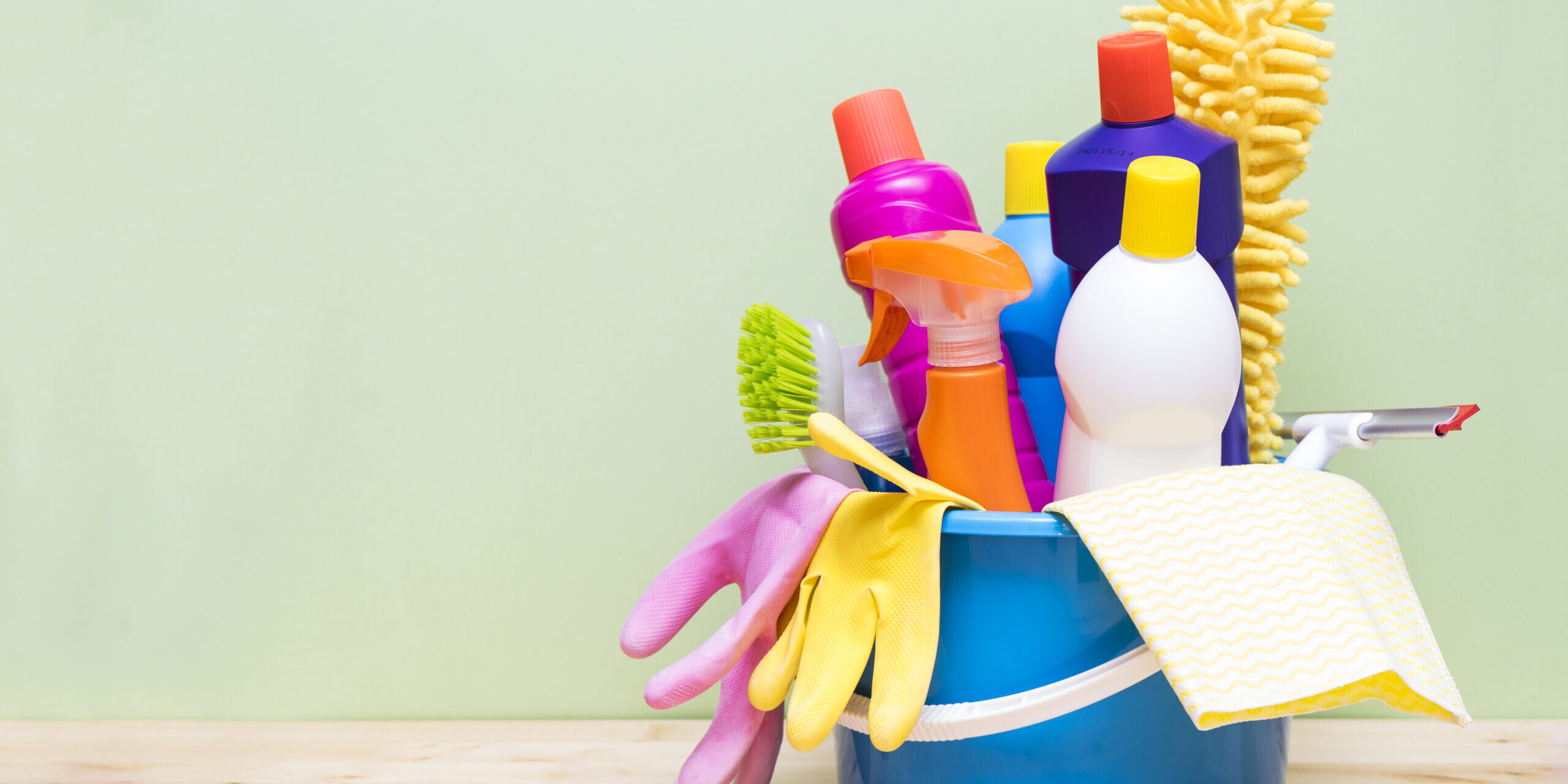 House cleaning product on wood table with green background
